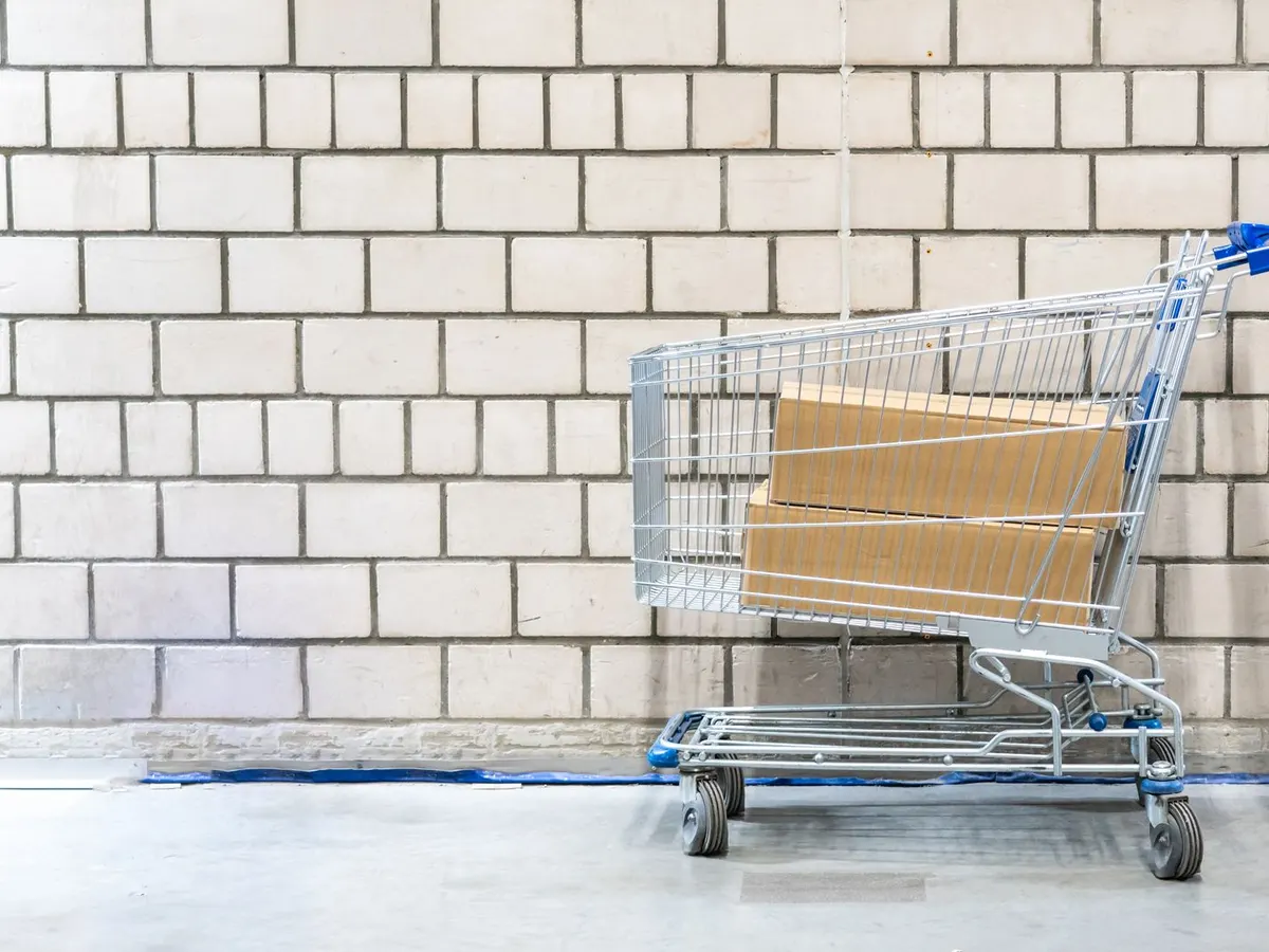 Zinc plated cash and carry trolley loaded with boxed goods in a wholesaler aisle