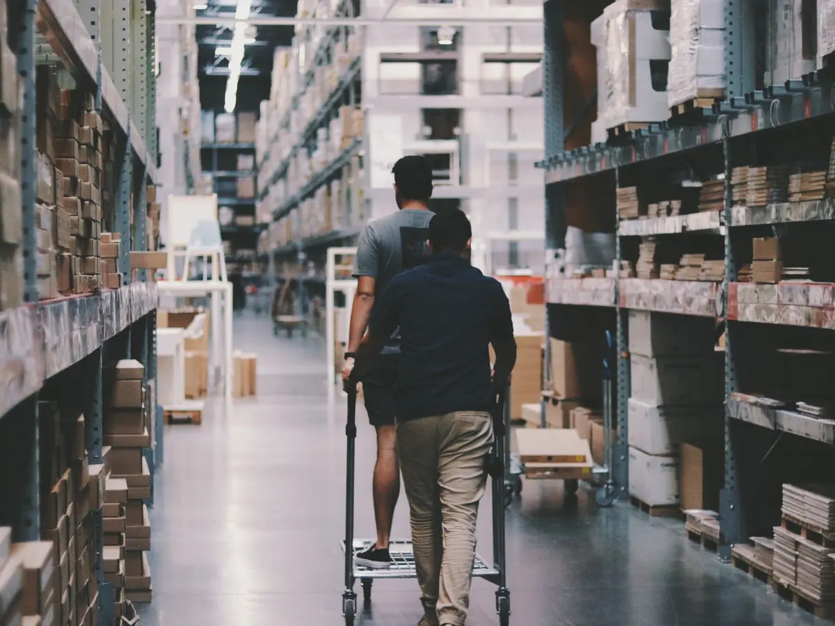 Lithium electric pallet truck moving a loaded pallet across a cash and carry floor