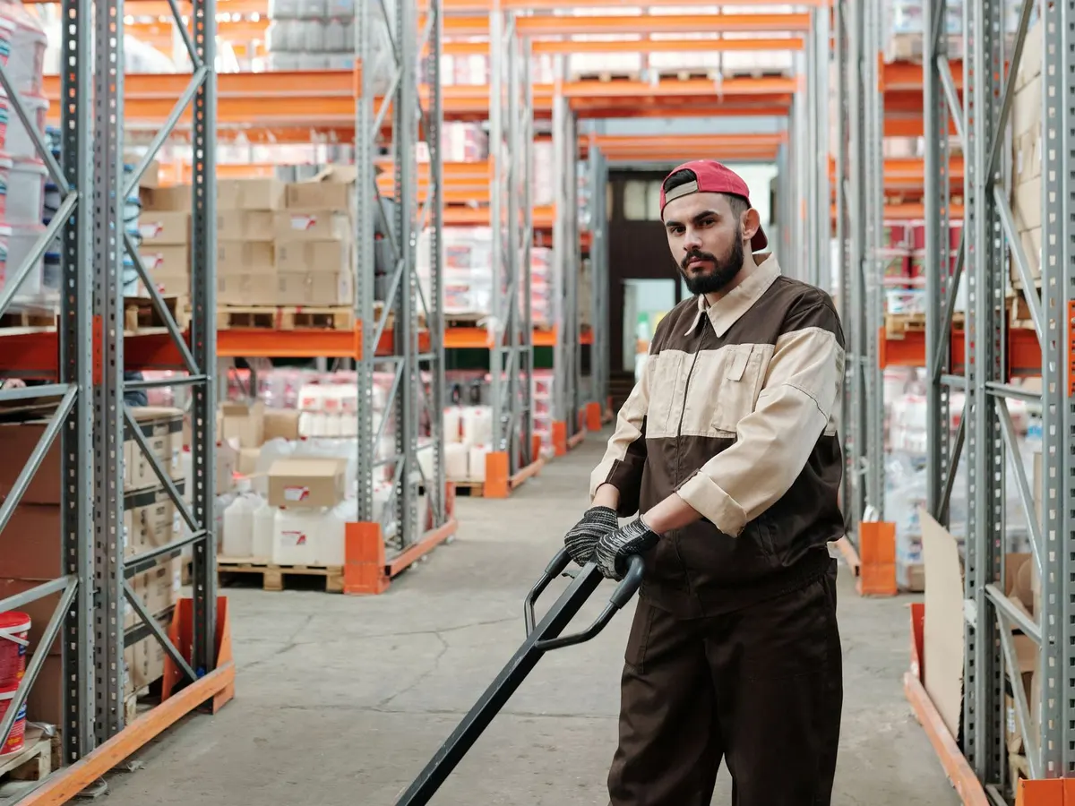 2500 kg hand pallet truck with polyurethane wheels under a loaded pallet on a cash and carry floor